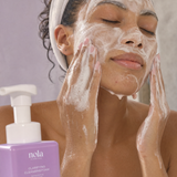 Woman cleansing her face with Clarifying Cleansing Foam.