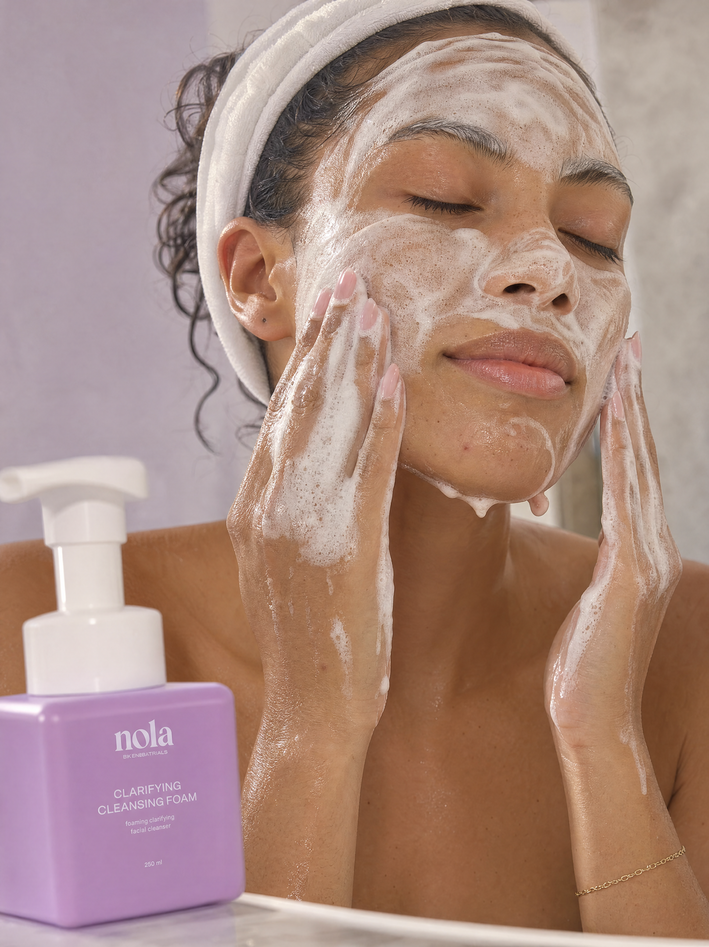 Woman cleansing her face with Clarifying Cleansing Foam.