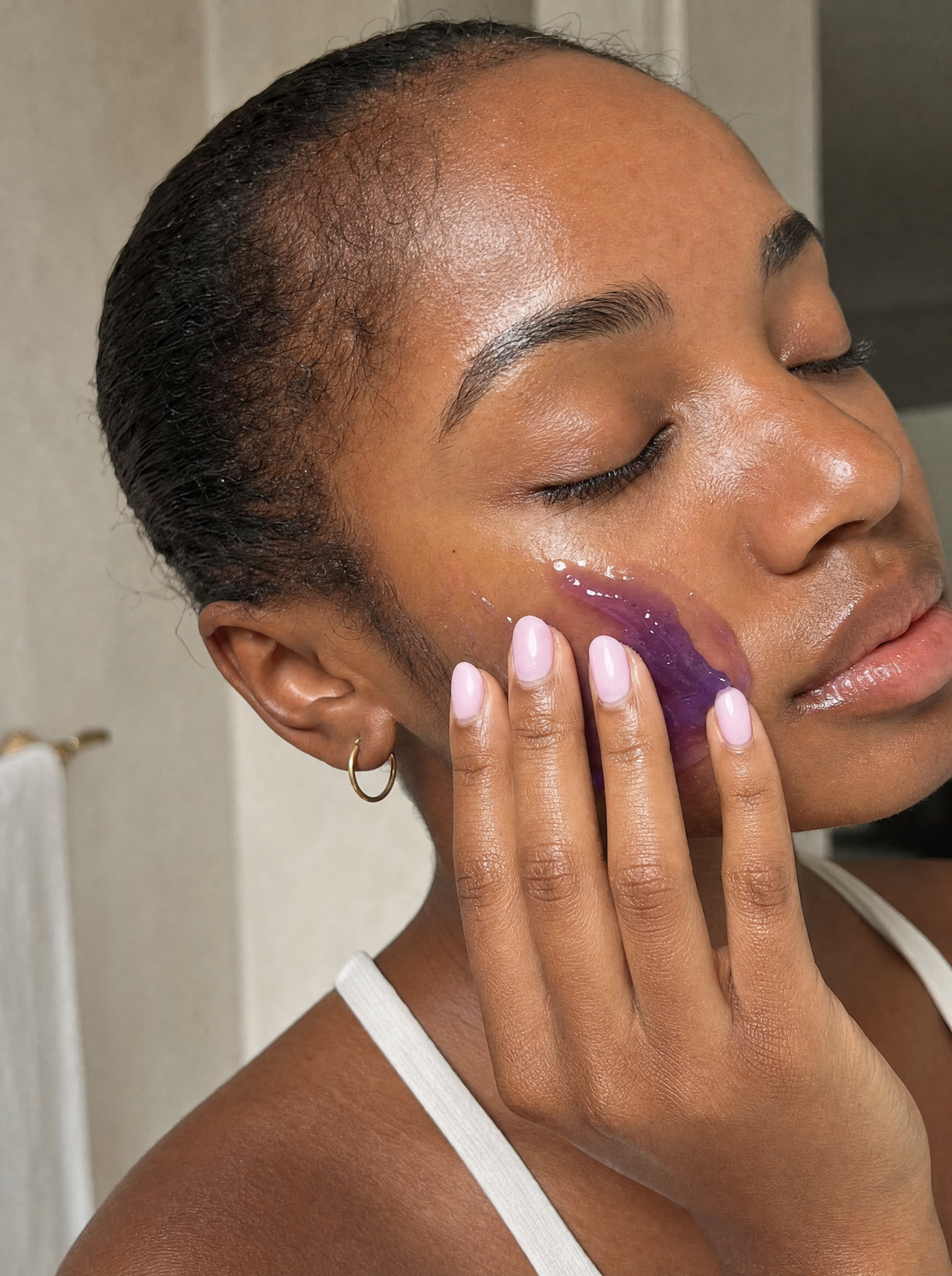 Woman applying The Real You Jelly Cleanser to her face during her routine.