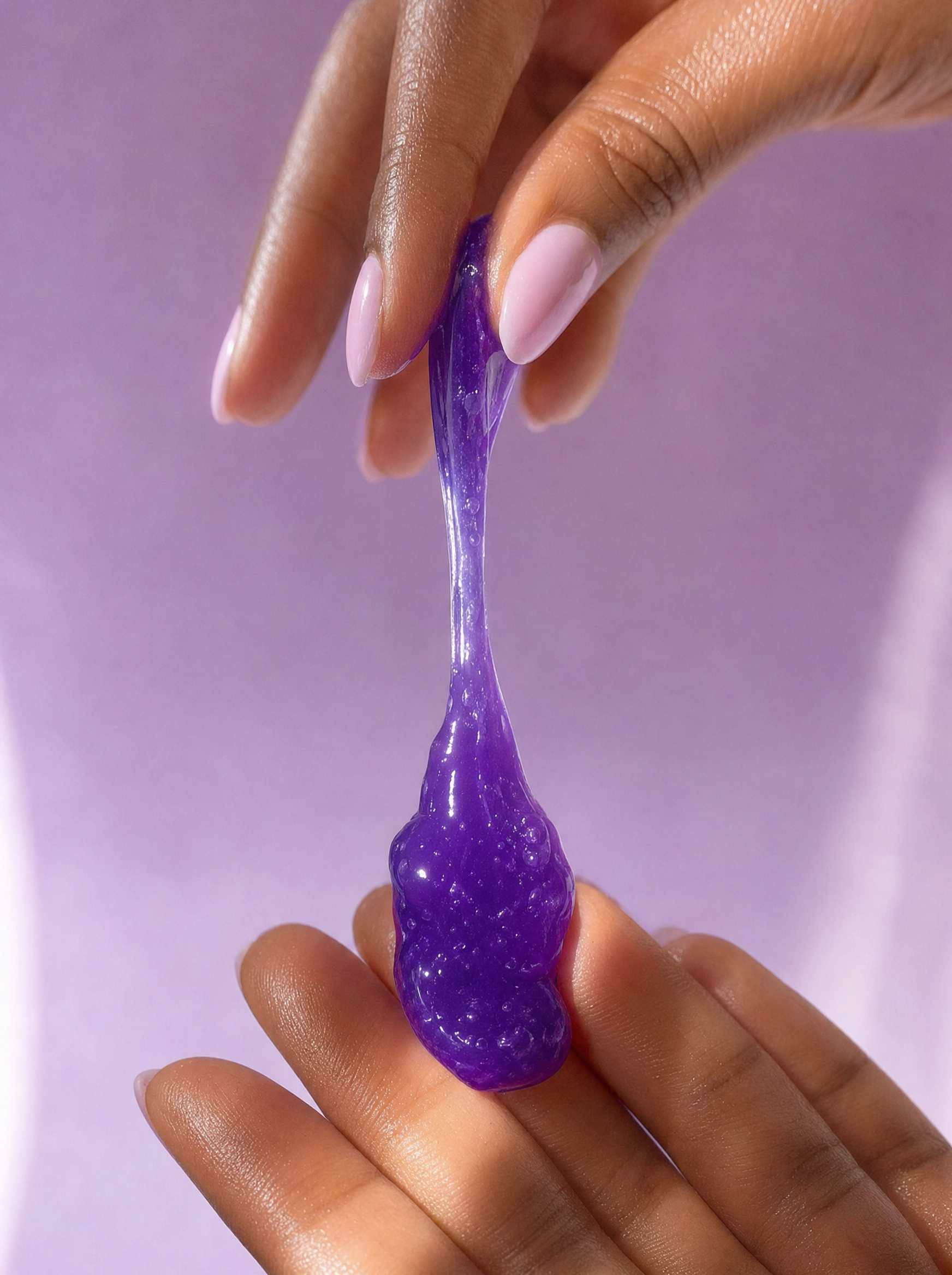 Close-up of the stretchy, jiggly purple jelly cleanser texture in hand.
