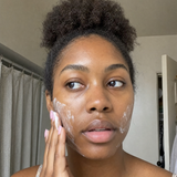 Woman applying Baby Skin face wash during her skincare routine.