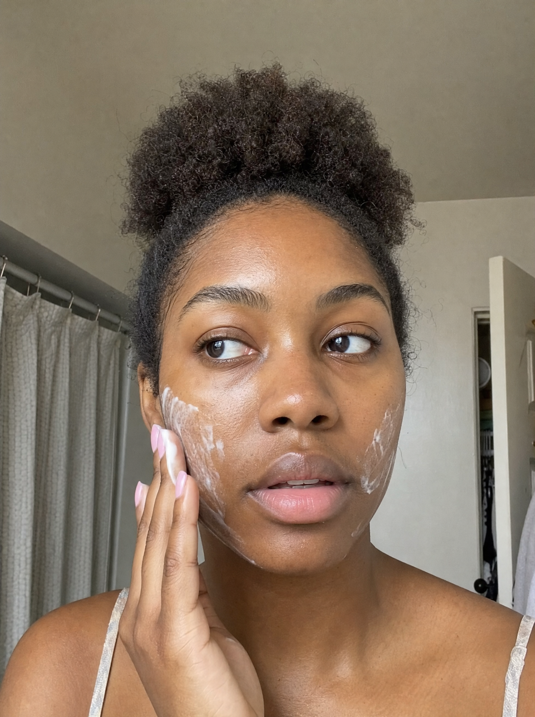 Woman applying Baby Skin face wash during her skincare routine.