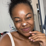 Woman smiling with Baby Skin face wash during her routine.
