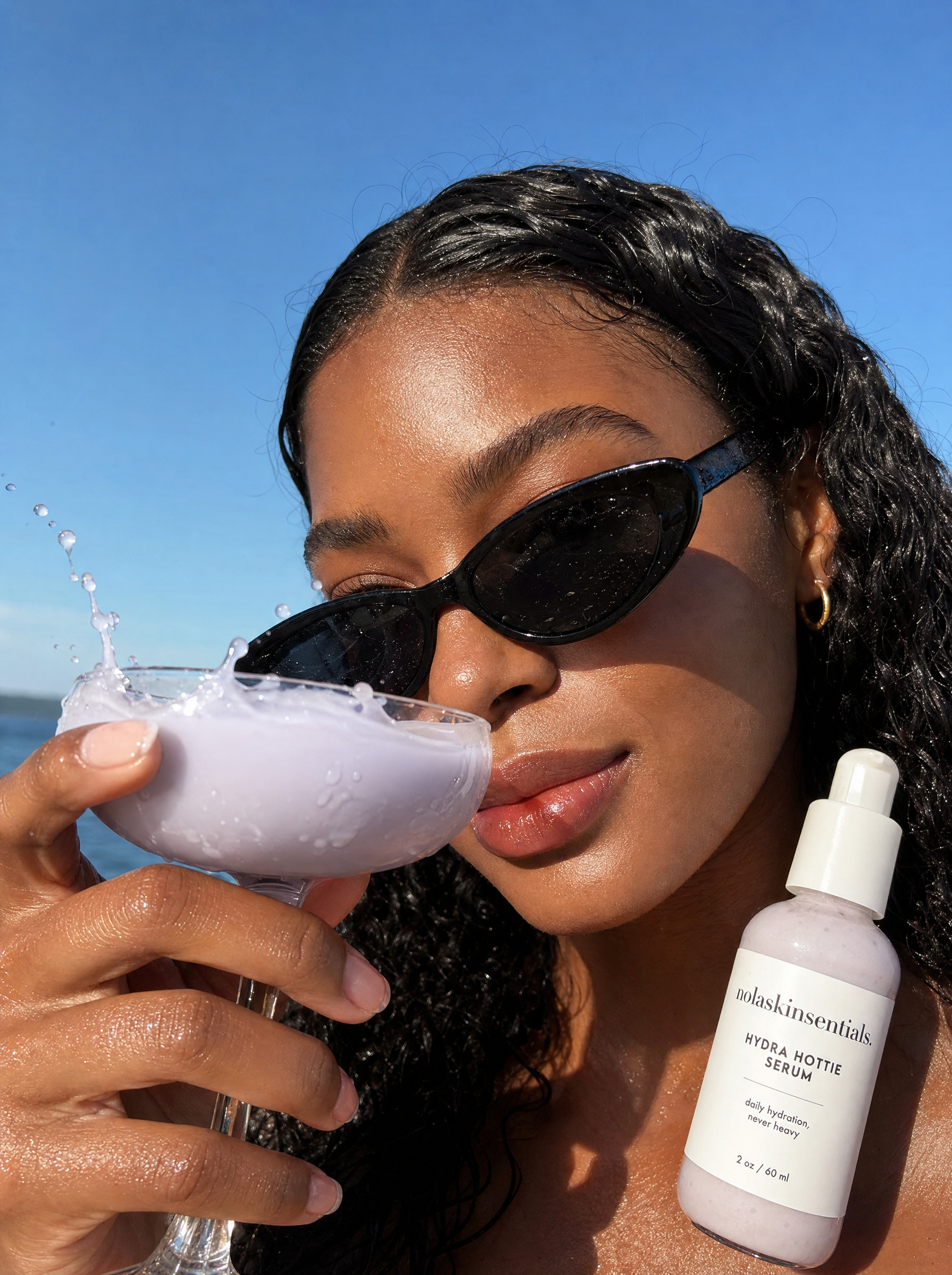 Model holding Hydra Hottie Serum outdoors in lavender-toned lifestyle shot by NOLA Skinsentials