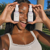 Smiling customer holding two Hydra Hottie Serum bottles outdoors — NOLA Skinsentials